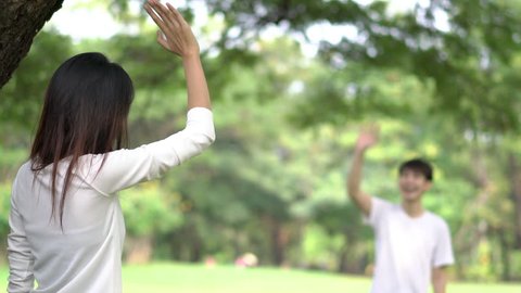 Teenage waving goodbye at outdoors in green park.