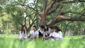 Six students meet doing homework together. People meeting team in the park outdoors. Man and woman using laptop computer.
