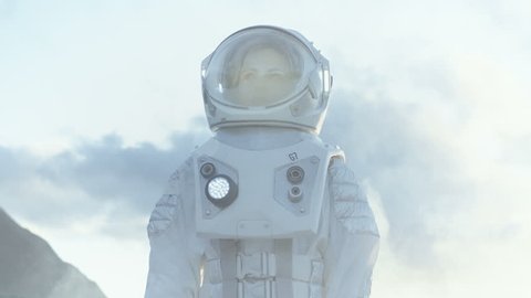 Medium Shot of Female Astronaut in the Space Suit Looking Around Frozen Alien Planet. Advanced Technologies, Space Travel, Colonization Concept. Shot on RED EPIC-W 8K Helium Cinema Camera.