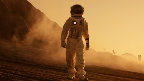 Proud Astronaut Confidently Walks on Mars Surface. Red Planet Covered in Gas and rock, Overcoming Difficulties, Important Moment for the Human Race. Shot on RED EPIC-W 8K Helium Cinema Camera.