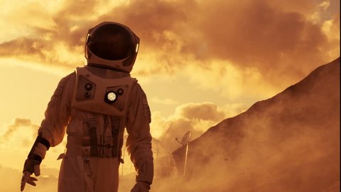 Handheld Side View Shot of the Astronaut Ascending Mountain on the Mars/ Red Planet. First Man on Alien Planet Overcoming Difficulties. Shot on RED EPIC-W 8K Helium Cinema Camera.