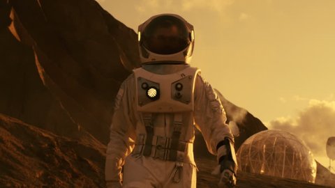 Astronaut on Mars Walking on the Exploring Expedition. In the Background His Base/ Research Station. First Manned Mission To Mars, Technological Advance Brings Space Exploration, Colonization. 4K UHD.