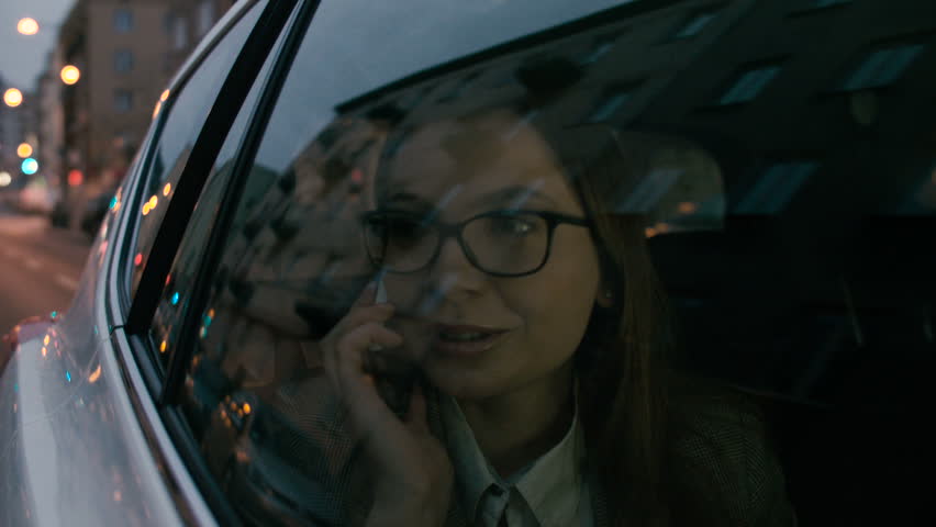 Young Woman Smiling During a Phone Call in the Car
