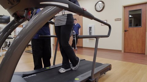 Medium shot of a senior woman walking on a rehabilitation treadmill