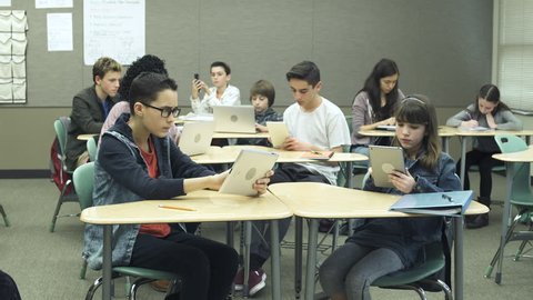 Wide shot of students using tablets in classroom