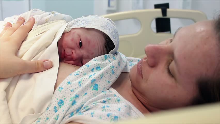 a newborn baby lies on the breast of a happy mother in the hospital. The first minutes of life. childbed. Royalty-Free Stock Footage #1008395302