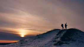 people winter silhouette does selfie photograph joy snow sunlight. group of tourists walking on top of a sunset silhouette mountain. slow video tourists people group go travel lifestyle nature
