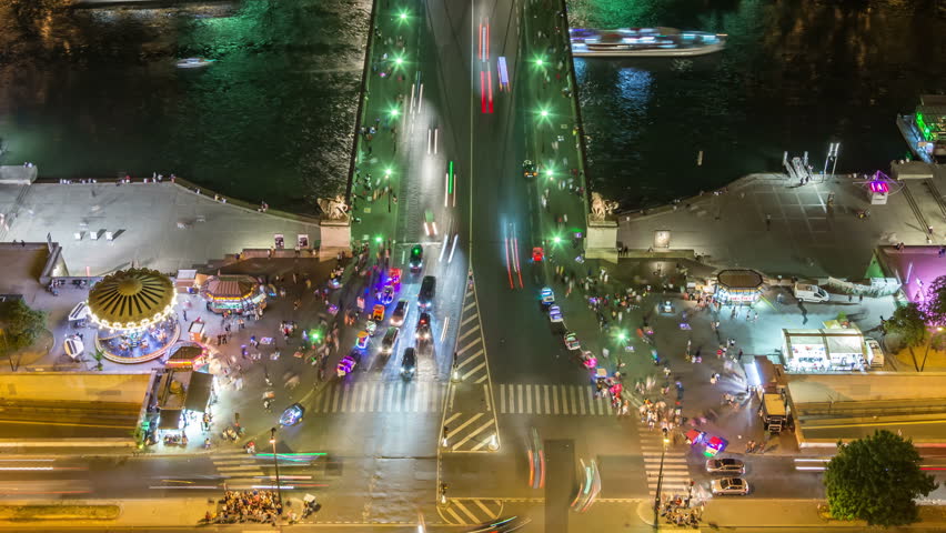 Night car traffic on Jena Bridge, over the river Seine in Paris. City lights and light trails. Aerial view. Tilt up shot.