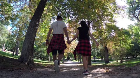 Buen Retiro Park, Madrid, Spain, Europe, Autumn 2017: Family Couple Holding Hands Together Walk Away In Tree Forest Along Path, Man and Woman In Casual Clothes, Romantic Background Footage