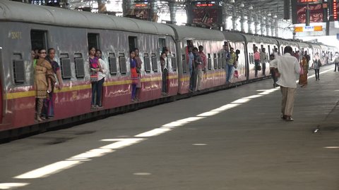 MUMBAI, INDIA - NOVEMBER 2014: Train passengers exit the carriages and enter the platform of the Victoria Terminus railway station in Mumbai, India