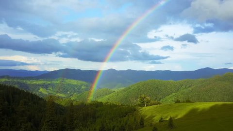 aerial view of rainbow in the mountains, flying in a rainbow in the rain, aerial view of Rainbow in mountain landscape, Rainbow in the Mountains and Dramatic Mountain Clouds After the Rain