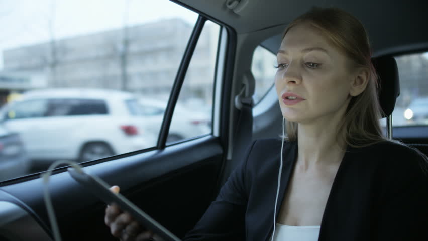 Woman Putting an Earphone in the Moving Car and Smiling | Shutterstock HD Video #1008415456
