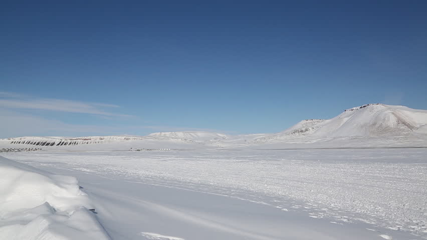 Inuit dog teams compete in the Nunavut Quest race in the High Arctic. Dog teams in a fan hitch glide across frozen ocean.