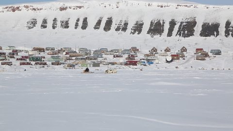 Inuit dog teams compete in the Nunavut Quest race in the High Arctic. Dog teams in a fan hitch glide across frozen ocean.