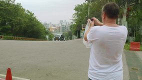 White tourist makes photo of street of asian city