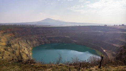 Time-lapse of open pit copper mine. Mountain carved into terraces for mining and forming an artificial lake.