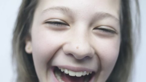 Close-up portrait of laughs girl in slow motion camera.