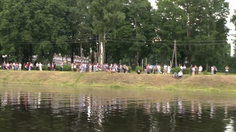 People having rest by the lake in a city park view