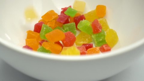 Colorful cubes candied fruit kiwi, mango, pineapple, strawberry (gummy candy) are falling. Slow motion