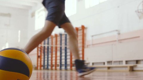 Volleyball Training. Schoolboys and schoolgirls run around the gym. Slow Motion.