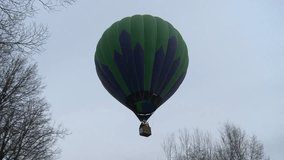 Hot air balloon flying above leafless trees video