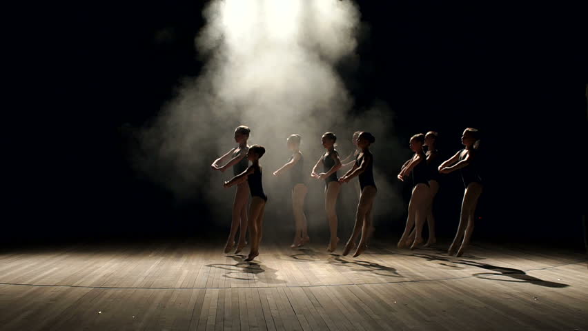 Young teen girls perform ballet on stage in smoke on black background. A choreographed dance of a group of graceful pretty young ballerinas practicing on stage in a classical ballet school. | Shutterstock HD Video #1008452200