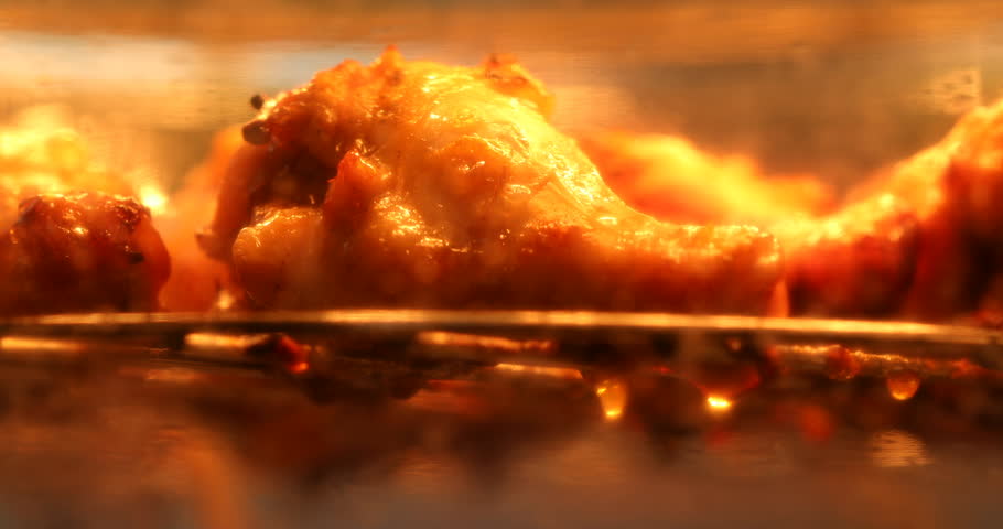 Extremely close up cooking chicken leg grill and bake in hot oven with burn and taking out of fat and oil 