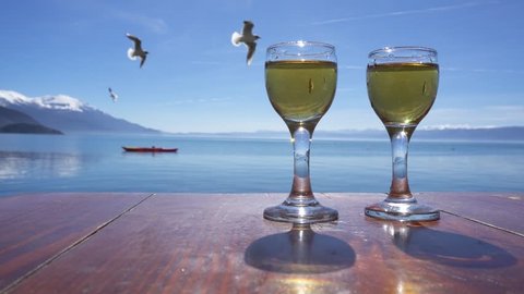Two glasses of rakija against Ohrid Lake on sunny day, Macedonia