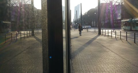 Frankfurt, Germany, circa 2016. Sidewalk activity on a street in Frankfurt, Germany. A girl walking on a sidewalk as traffic moves to her right. The European Central Bank building in the background. 