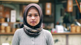 Portrait of beautiful south east asian muslim woman with hijab smiling on camera with three kind of tones (cyan - orange, contrast, and raw)