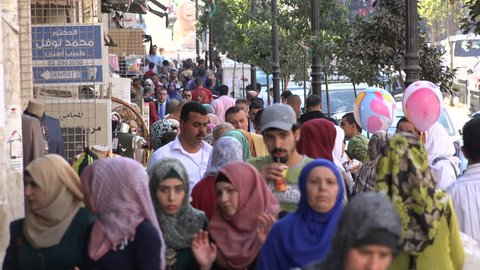 RAMALLAH, WEST BANK - OCTOBER 2016: Diverse crowds walk through a shopping street in downtown Ramallah city in the Palestinian Territories