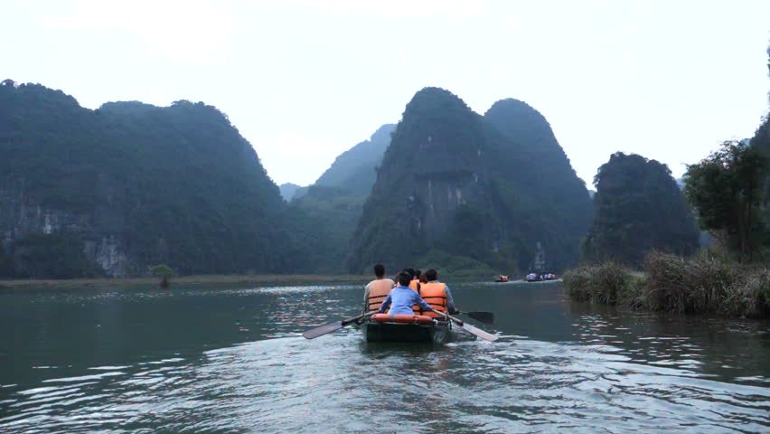 Tourist are traveling by sitting on the rowing boat in the river, Ninh Binh, Vietnam.