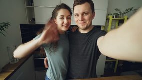 POV of Young happy couple talking online video chat in the kitchen at home