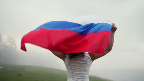 Russian girl running with flag in a beautiful landscape