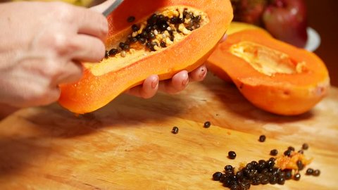 exotic fruits on the table. 4k, women's hands prepare papaya for a cutting board