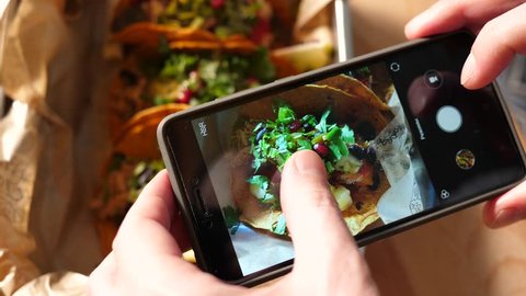 Food photo with a mobile phone a guy in Mexican cuisine restaurant takes pictures for social media