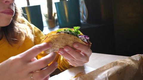 Young woman enjoy eating tacos in Mexican cuisine restaurant - portrait with food