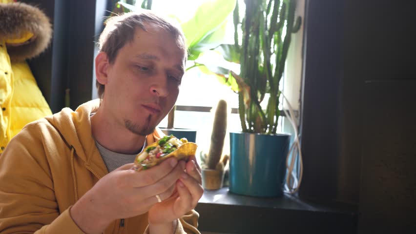 Young man enjoy eating tacos in Mexican cuisine restaurant - portrait with food