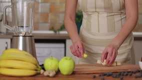 Woman is puting banana in blender, slow motion video