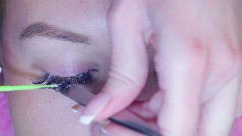 Close up. The master in the beauty salon removes the old eyelashes, preparing the patient for the process of eyelash extension