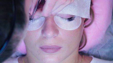 Time lapse. Close up woman face. Eyelash extension procedure. Young woman in a beauty salon