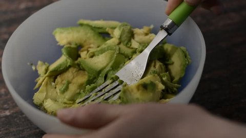 Making guacamole with a fork, avocado recipe, cooking guacamole