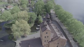 Aerial view of Historical and cultural complex Castle-museum Radomysl- the museum of Ukrainian home icons. Flying around the Radomyshlsky Castle with a view of the surrounding landscapes of the lake