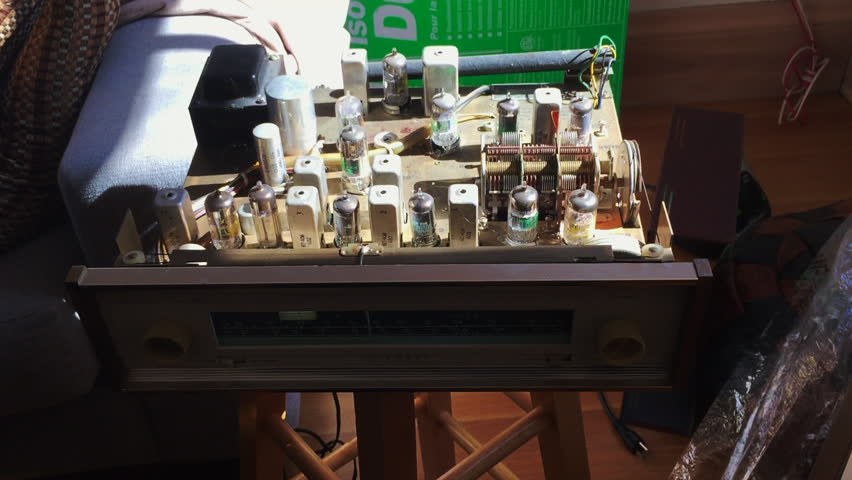 Quick smooth zoom shot into the old style workings of a stereo, revealing engineering electronics, tubes and layout
