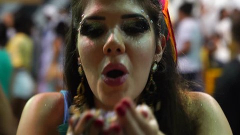 Girl blowing colorful confetti at Salvador Carnaval, Brazil