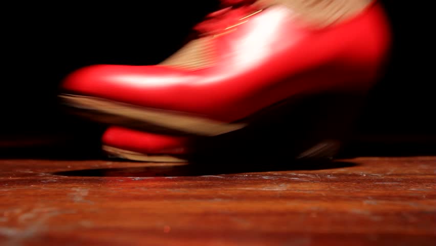 Flamenco dancer dancing traditional flamenco dance on wooden floor and dark background. Royalty-Free Stock Footage #1008564955