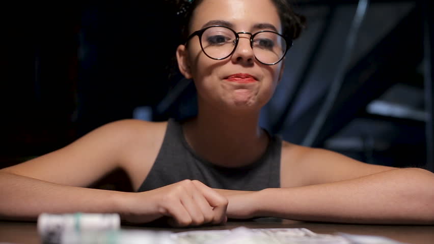 Young girl playing wih bank notes by the gaming table