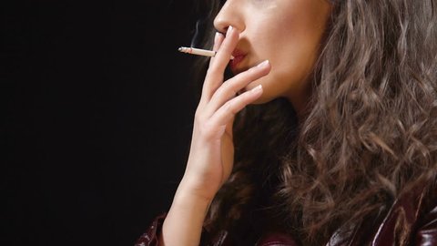 Attractive brunette smoking cigarette alone, bad habits among youth, close up