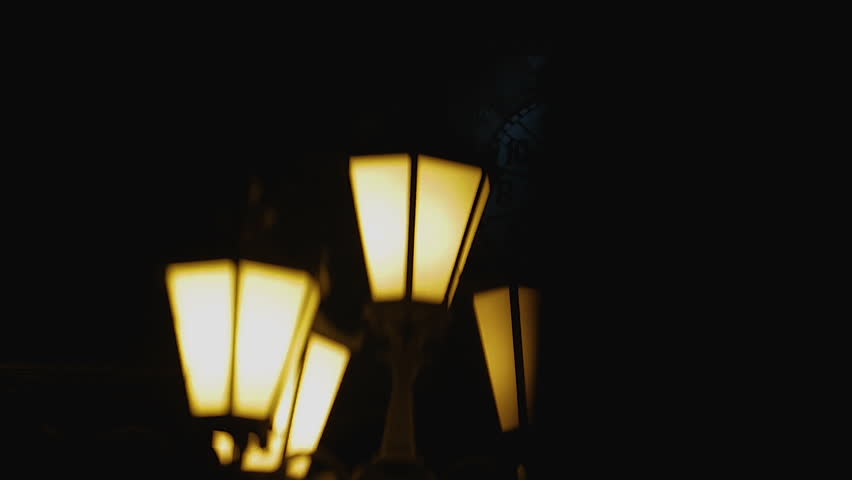 Dark silhouette passing by street lantern, horror story covered with night