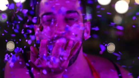 Guy blowing colorful confetti